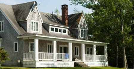 white and brown wooden house near green trees during daytime